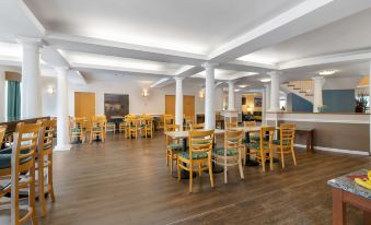 a large dining room with wooden tables and chairs arranged for a group of people at Best Western Plus Executive Court Inn  Conference Center