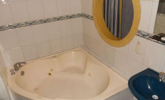 a bathroom with a white bathtub and a blue bathtub cover , along with a toilet in the background at Hotel Posada del Hidalgo