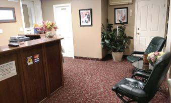 a modern office with carpeted floors , wooden furniture , and a reception area decorated with plants and flowers at Country Inn Listowel