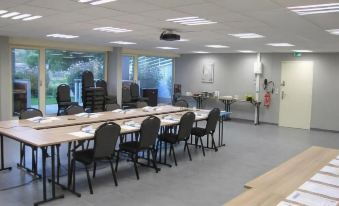 a large conference room with multiple tables and chairs arranged for a meeting or training session at Hotel & Spa Radiana