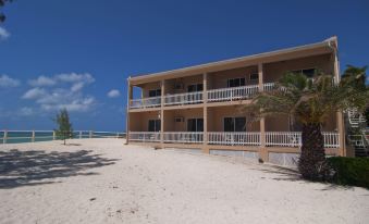 a beach scene with a row of beachfront hotels and resorts , such as the sandbank resort at Bohio Dive Resort