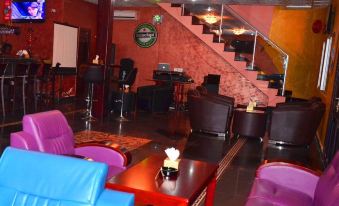 a lively bar with multiple couches and chairs , as well as a dining table in the background at Executive Inn