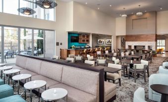 a modern , well - lit living room with white couches and chairs arranged around a coffee table , creating a cozy atmosphere at Homewood Suites by Hilton Aliso Viejo Laguna Beach