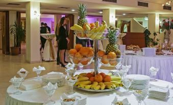 a table is set with plates , bowls of fruit , and plates of snacks in the background at Flamengo