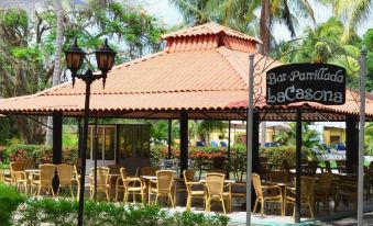 an outdoor dining area with a gazebo and several chairs arranged around it , creating a pleasant atmosphere at Hostal la Casona