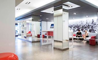 a modern office space with a large , white building and red red sculpture in the foreground at Novotel Montreal Center