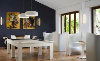 a modern living room with a dining table , chairs , and a pool table , surrounded by white furniture and blue walls at Hotel la Playa