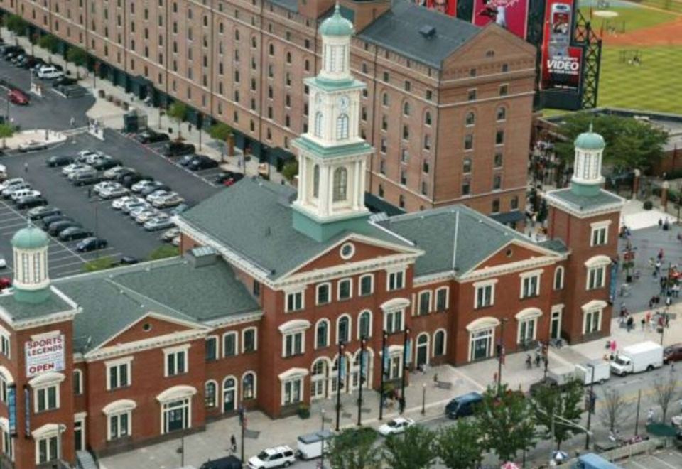 a large brick building with a tower and clock is surrounded by a parking lot at Sonesta Select Columbia