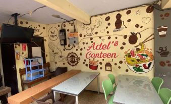 a restaurant with a wall mural of food and drinks , as well as tables and chairs for dining at Adel Guest House