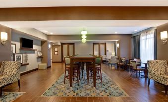 a large room with a wooden floor , several chairs , and a dining table in the center at Hampton Inn-DeKalb (Near the University)