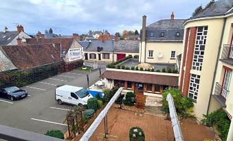 a parking lot in front of a building , with several cars parked in the lot at Hôtel Saint-Hubert