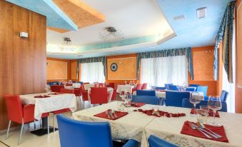 a large dining room with multiple tables and chairs arranged for a group of people to enjoy a meal together at Hotel Centrale