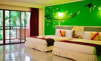 a hotel room with two beds , one on the left and one on the right side of the room at Baanrai Riverkkwai Resort