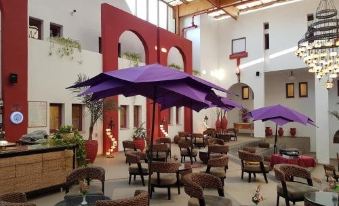 The restaurant features tables and chairs in the middle, alongside an open-air area that offers a scenic view of the surrounding landscape, creating an enjoyable dining experience for guests at Desert Sounds - Boutique Hotel