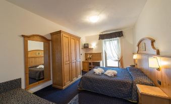 a hotel room with a bed , a dresser , and a tv . the room is clean and well - organized at Hotel Italia