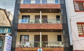 "a modern building with wooden balconies and a sign that says "" happy home "", surrounded by other buildings and trees" at Hotel Rajlaxmi Grand