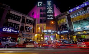 a busy city street at night , with numerous cars and motorcycles driving down the road at Hako Hotel (Mount Austin)