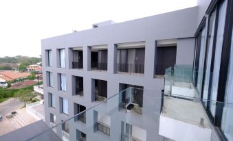 a modern building with multiple balconies and a glass railing , situated in a urban environment at R Photo Hotel