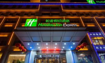 a building with the hilton express sign lit up , creating a festive atmosphere at night at Holiday Inn Express
