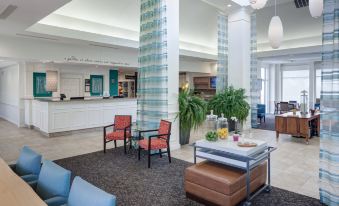 a large hotel lobby with multiple chairs and couches , as well as a dining table and chairs at Hilton Garden Inn Hilton Head