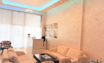 a modern living room with white walls , a black coffee table , and beige couches arranged around it at Comfort Hotel