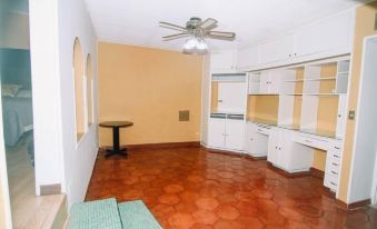 a room with a red brick floor and white cabinets , a ceiling fan , and a fan at La Esperanza