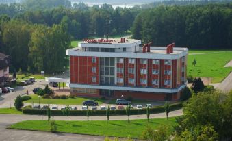 an aerial view of a large building with a red and white facade , surrounded by trees and grass at Hotel Regent