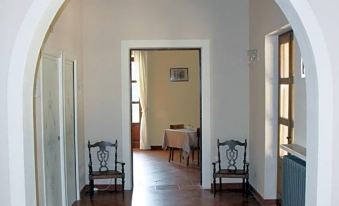 a long hallway with two chairs on either side and an open doorway at the end at Villa Luisa