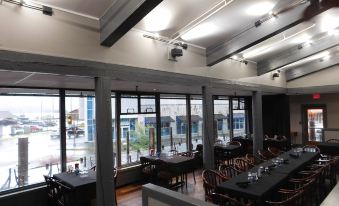 a restaurant with wooden tables and chairs , large windows , and exposed beams , providing a comfortable atmosphere at Westmark Sitka
