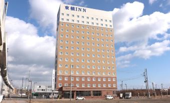 "a tall building with the name "" inn "" on it is shown in front of some cars" at Hotel Aomori