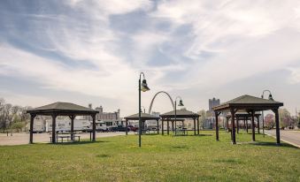 a park with several wooden benches , a gazebo , and a city skyline in the background at Casino Queen Hotel