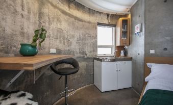 a small kitchen area with a dining table , a sink , a microwave , and a refrigerator at Klettar Tower Iceland