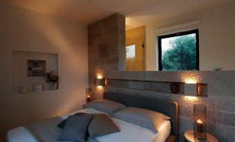 a cozy bedroom with a large bed , two nightstands , and a window overlooking a beautiful garden at Masseria le Fabriche