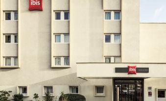 "a modern building with a red sign that reads "" ibis "" on the side , located in a city setting" at Ibis Epinay Sur Seine - Gennevilliers