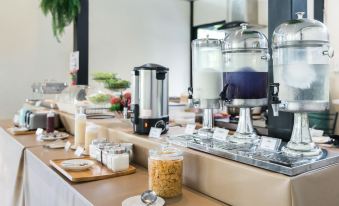 a buffet table filled with a variety of food items , including bowls of cereal and a variety of beverages at Pimtara Beach Resort