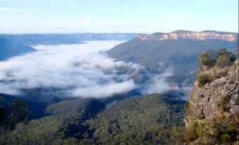 a breathtaking view of a mountainous landscape with fog and clouds , taken from a high vantage point at Maya Sanctuary