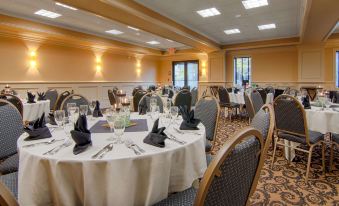 a large banquet hall with multiple tables set for a formal event , each table having its own name and place card at Grand Hotel at Bridgeport