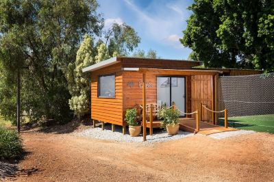 "a small wooden cabin with a sign reading "" rac camp "" is surrounded by trees and grass" at The Swan Valley Retreat