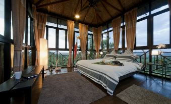 a bedroom with a large bed and a view of the mountains outside the window at Bilut Hills @ Bentong