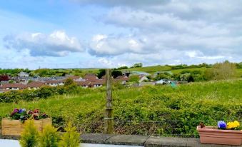 a rural landscape with a wooden cross in the foreground and a house in the background at Number 19 Guest House - 4 Miles from Barrow in Furness - 1 Mile from Safari Zoo