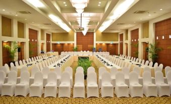a large , empty conference room with rows of white chairs and a long table in the center at Kurumba Maldives
