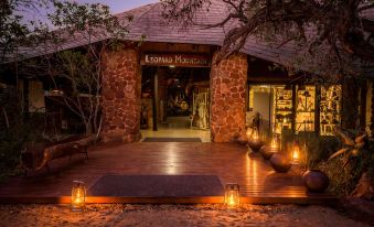 a stone building with lanterns hanging from the ceiling , creating a warm and inviting atmosphere at Leopard Mountain Safari Lodge