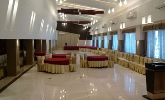 a large , empty banquet hall with multiple rows of red tables and chairs , creating a festive atmosphere at Hotel Miramar