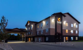 an exterior view of a comfort inn hotel at night , with the hotel building illuminated at Comfort Inn & Suites