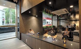 a modern coffee shop with a woman sitting at a table , enjoying a cup of coffee at 57Hotel