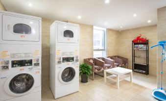The room next to an open laundry area is spacious and equipped with washing machines and dryers at Holiday Inn Express Chengdu West Gate