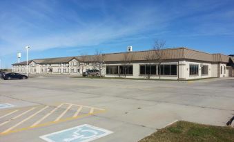 a large building with a handicapped parking space in front of it , under a clear blue sky at Country Inn & Suites by Radisson, Sidney, NE