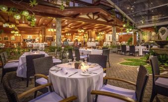 a restaurant with tables and chairs set up for dining , surrounded by a brick patio at The Manor at Camp John Hay