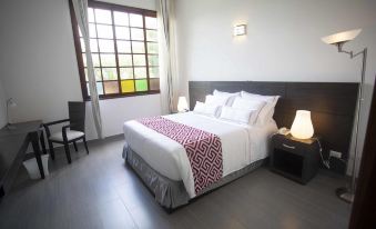a clean , well - organized bedroom with a large bed , white linens , and a red and white comforter at Hotel Union