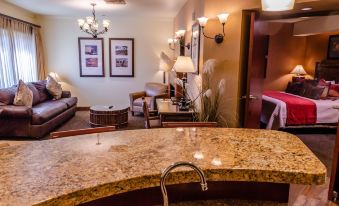 a kitchen counter with a sink and a living room in the background , decorated with furniture and lights at Lodge at Feather Falls Casino
